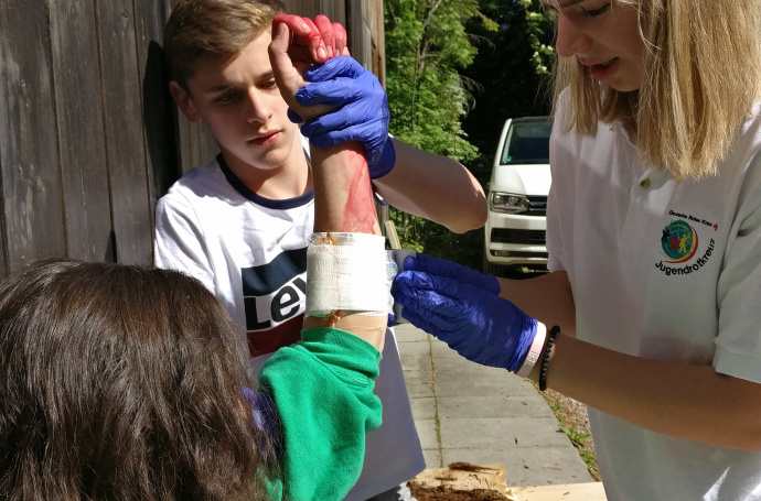 An der Erste-Hilfe-Station versorgen Nele und Lukas eine verletzte Patientin.