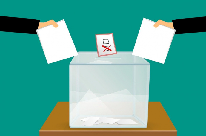 Symbolbild Wahlen mit Urne und zwei Wähler:innen